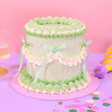Vintage Cake - Tonal Colour with hand-piped green and white Swiss Meringue icing and pastel ribbon decoration by Crumbs & Doilies